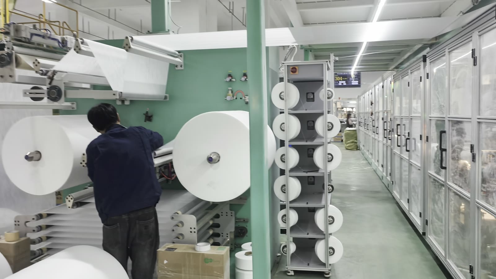 Operator loading a nonwoven roll onto an unwind stand